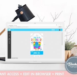May include: A laptop displays a printable tag design with a popsicle graphic. The tag reads "THANK YOU FOR POPPING BY" and includes the name "Anna Bell." The design features rainbow colors and is on a white background.