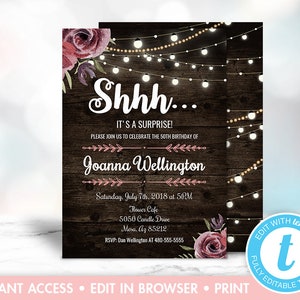 Puede incluir: Un fondo de madera rústico con luces de cadena y detalles florales. El texto "Shhh... ¡Es una sorpresa!" está escrito en blanco. El texto "Por favor, únase a nosotros para celebrar el 50 cumpleaños de Joanna Wellington" está escrito en rosa. El texto "Sábado, 7 de julio de 2018 a las 5:00 PM" está escrito en negro. El texto "Flower Cafe, 5050 Candle Drive, Mesa, AZ 85212" está escrito en negro. El texto "RSVP: Dan Wellington AL 480-555-5555" está escrito en negro.