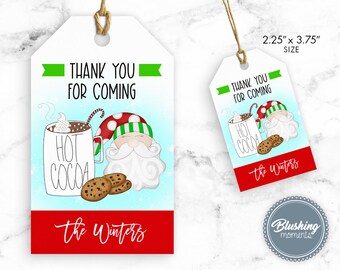 Könnte beinhalten: Ein weißes Dankeschön-Etikett mit einer Illustration eines roten und grünen Weihnachtsmanns, der eine Tasse heiße Schokolade und Kekse hält. Das Etikett lautet "Vielen Dank für Ihr Kommen" und "The Winters". Das Etikett ist 5,7 cm x 9,5 cm groß.