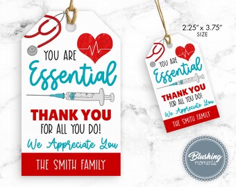 May include: A white gift tag with red and blue accents. The tag features a stethoscope, a heart with a heartbeat line, a syringe, and the text "You are Essential Thank You for all you do! We Appreciate You The Smith Family". The tag measures 2.25 inches by 3.75 inches.