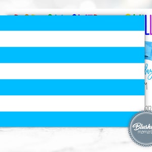 May include: A white card with horizontal blue stripes. The card has text that reads "Happy Birthday!" and "Blushing Moments" in a circular logo. A blue bow is also visible.