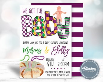 May include: A purple, green, and yellow baby shower invitation with the text "We got the Baby" and a cartoon baby on top of the letter "Y". The invitation also includes the names "Marcus & Shelly", the date "February 18th", the time "2:00PM", and the address "1218 Cupid Street, Mesa, AZ 85212".