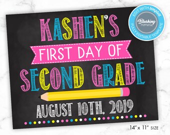 May include: A chalkboard sign with the text "KASHEN'S FIRST DAY OF SECOND GRADE AUGUST 10TH, 2019" in colorful, handwritten font. The sign is decorated with a yellow pencil and colorful dots.