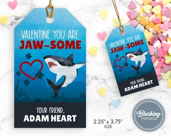 May include: A blue Valentine's Day gift tag with a white shark and a red heart. The tag says "Valentine You Are Jaw-Some" and "Your Friend, Adam Heart". The tag is 2.25 inches by 3.75 inches.