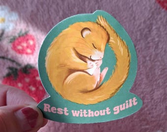 May include: A green and yellow sticker with a cartoon illustration of a sleeping dormouse. The sticker has the text "Rest without guilt" in pink.