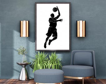 May include: A framed black and white silhouette art print of a basketball player mid-jump, about to shoot the ball. The artwork is displayed on a teal wall, complemented by gold-toned sconces and a modern seating arrangement.