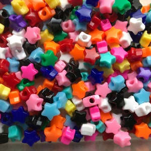 May include: A large assortment of colorful star-shaped plastic beads. The beads are in a variety of colors, including red, orange, yellow, green, blue, purple, pink, and white.