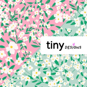 Peut inclure: Motif floral avec des fleurs blanches à cœur jaune et des feuilles vertes sur fond rose et vert clair. Le texte "tiny designs" est affiché sur une étiquette rectangulaire blanche.