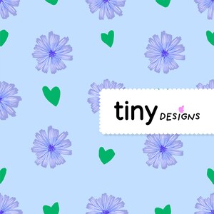 Peut inclure: Un fond bleu clair avec un motif répétitif de fleurs bleues et de coeurs verts. Le texte "tiny designs" est affiché dans un rectangle blanc avec un bord festonné.
