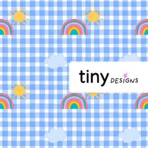 Peut inclure: Motif répété de soleils, d'arcs-en-ciel et de nuages sur un fond vichy bleu et blanc. Le texte "tiny designs" est affiché dans un rectangle blanc. Le design est joyeux et fantaisiste.
