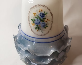 Pode incluir: Um abajur de vidro branco com um design floral azul e branco e uma borda azul com babados.