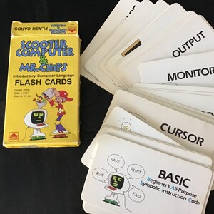 May include: A yellow box of "Scooter Computer & Mr. Chips" flash cards with a cartoon illustration. The box is next to a stack of white flash cards with computer terms like "Output" and "Basic". Card size is 3.5" x 5.5".