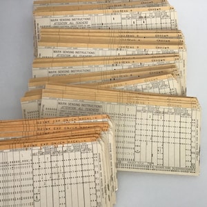 May include: A stack of yellowed, paper answer sheets with a grid of small circles for marking answers. The sheets have the text "MARK SENSING INSTRUCTIONS ATTENTION ALL TEACHERS" printed on them. The text "OZINK EXP ON/CH MACKLIN" is also visible.