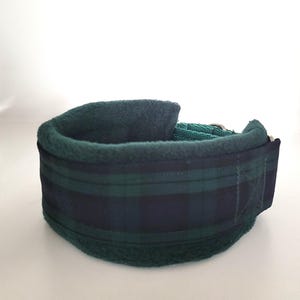 Puede incluir: Un collar para mascotas con un exterior de tela a cuadros en verde oscuro y azul marino. El interior est&aacute; forrado con un material de forro polar suave en color verde oscuro. El collar incluye una hebilla de metal y una correa de nailon.