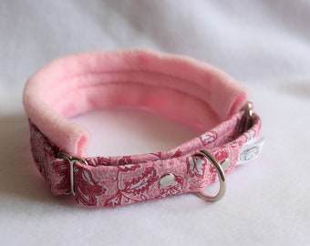 May include: Pink and white floral dog collar with a pink fleece lining. The collar has a silver buckle and D-ring.