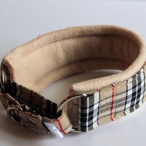 Puede incluir: Un collar acolchado para perros con forro polar beige y un estampado a cuadros en beige, negro y rojo. El collar tiene una anilla en D de metal y una hebilla. Dise&ntilde;o cl&aacute;sico y elegante.
