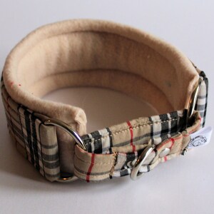 Puede incluir: Un collar acolchado para perros, beige y a cuadros. El collar tiene un interior suave de color crema y un exterior a cuadros con cuadros beige, negros y rojos. Cuenta con herrajes met&aacute;licos plateados.