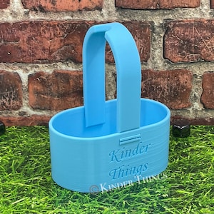 May include: A light blue plastic container with a handle. The container has the words "Kinder Things" printed on the side.