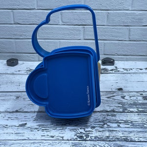 May include: Blue plastic mold for making a sandwich in the shape of a coffee mug. The mold is made by Kinder Things.