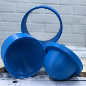 May include: Three blue plastic molds for making resin crafts. The molds are in the shape of a dome, a ring, and a half-dome.
