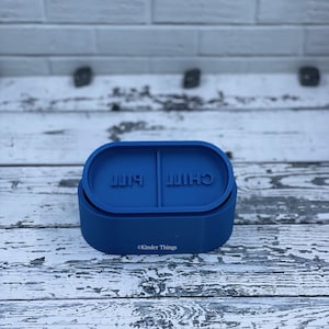 May include: A blue silicone pill box with the words "Chill Pill" printed on it.