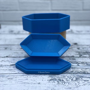 May include: Three blue hexagonal nesting boxes with the text "Kinder Things" on the bottom box.