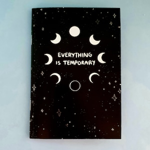 May include: Black notebook with white stars and moons. The text "Everything is Temporary" is written in white on the front cover.