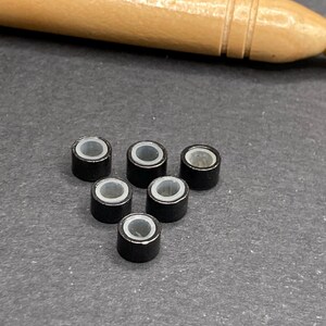 Kit de crochet + 6 cuentas en marrón claro, blanco o negro (a elegir). Cuentas para sujetar plumas, pelo o hebras de colores. Negro