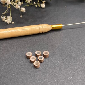 Kit de crochet + 6 cuentas en marrón claro, blanco o negro (a elegir). Cuentas para sujetar plumas, pelo o hebras de colores. Marrón