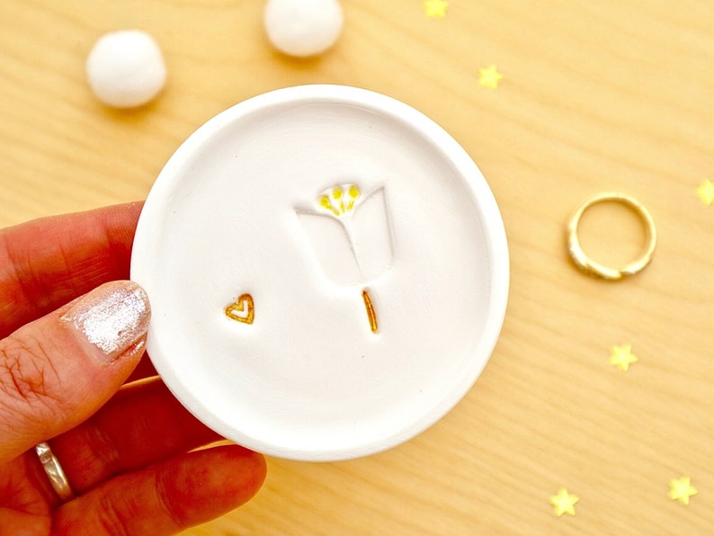 Personalised white tulip ring, trinket dish, handmade from white clay. With a hand stamped tulip, with a gold stem and yellow stamen and gold love heart. Gift for nature lovers. Gift for her- for weddings, birthdays, anniversaries, Mother's Day.