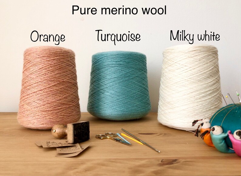 Puede incluir: Tres carretes de hilo de lana merino puro en naranja, turquesa y blanco lechoso. El hilo est&aacute; enrollado en conos y est&aacute; listo para tejer o hacer ganchillo.