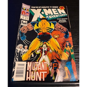 May include: A white ceramic mug with a black handle and the text "But First, Coffee" in a handwritten style. The mug is on a white surface. The mug is approximately 4 inches tall.