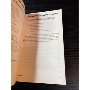 May include: Open cookbook page featuring a recipe for Lemon Dijon Baked Fish. The recipe includes ingredients like orange roughy fillets, Dijon mustard, and lemon juice. The page number 33 is visible.
