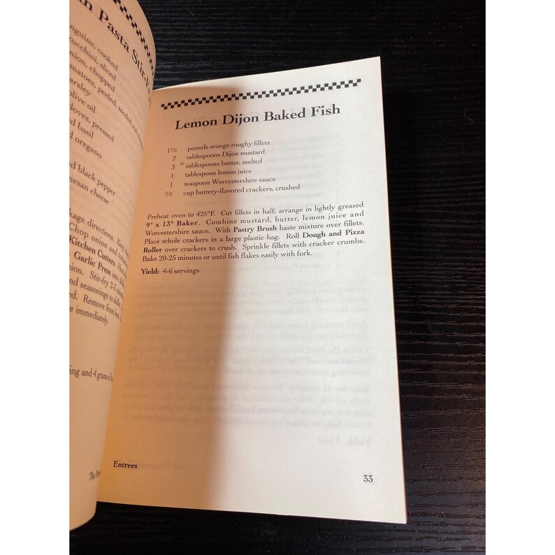May include: Open cookbook page featuring a recipe for Lemon Dijon Baked Fish. The recipe includes ingredients like orange roughy fillets, Dijon mustard, and lemon juice. The page number 33 is visible.