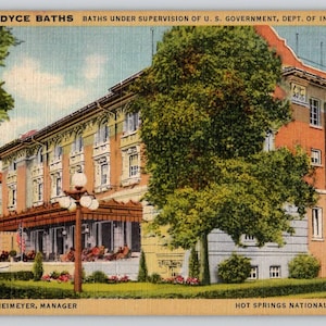 May include: Vintage postcard of the Fordyce Baths in Hot Springs National Park, Arkansas. The multi-story building has a detailed facade with a covered porch and is surrounded by trees and landscaping. Text includes "FORDYCE BATHS" and "HOT SPRINGS NATIONAL PARK, ARK."