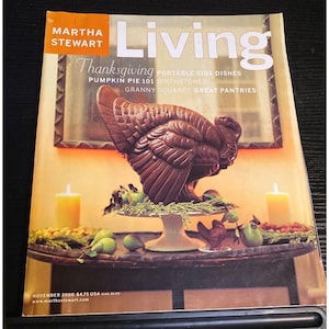 May include: A magazine cover featuring a Thanksgiving theme. The cover shows a chocolate turkey centerpiece on a cake stand, surrounded by pears, candles, and decorative elements. The magazine title is "Living" by Martha Stewart.