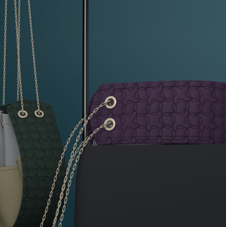 May include: A purple handbag with a chain strap and two silver metal rings. The bag has a textured, quilted design.