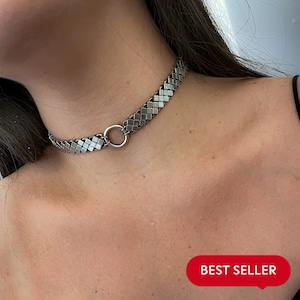 Op de afbeelding: Een zilveren choker ketting met een geometrisch patroon en een ronde ring sluiting. De ketting is een bestseller.