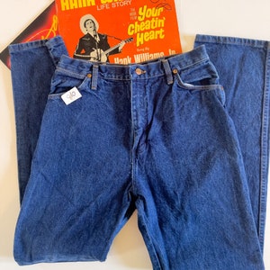 Puede incluir: Un par de pantalones vaqueros de mezclilla azul oscuro con cintura alta y pierna recta. Los vaqueros tienen un estilo cl&aacute;sico de cinco bolsillos y cierre de bot&oacute;n.