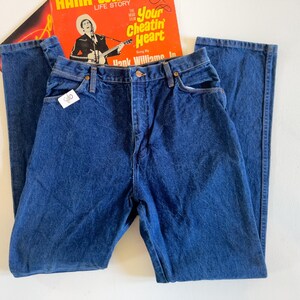 Puede incluir: Un par de pantalones vaqueros de mezclilla azul oscuro con corte recto. Los pantalones tienen cierre de bot&oacute;n y cinco bolsillos.