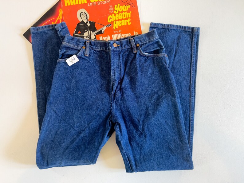 Puede incluir: Un par de pantalones vaqueros de mezclilla azul oscuro con corte recto. Los pantalones tienen cierre de bot&oacute;n y cinco bolsillos.