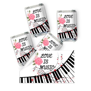 May include: Four small chocolate bar wrappers with a white background and a pink rose, musical notes, and a black and white piano keyboard. The text on the wrappers reads "Love is Music".