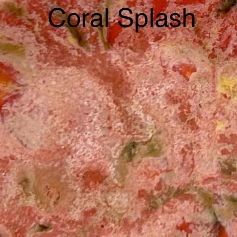 A close-up of a glaze sample labeled "Coral Splash," displaying a textured surface with mottled coral, red, and white colors.