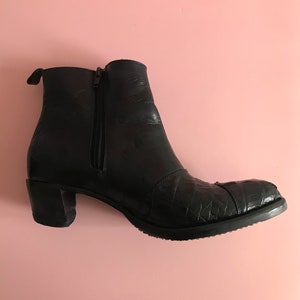 May include: Black leather ankle boots with a zipper on the side and a textured pattern on the toe.