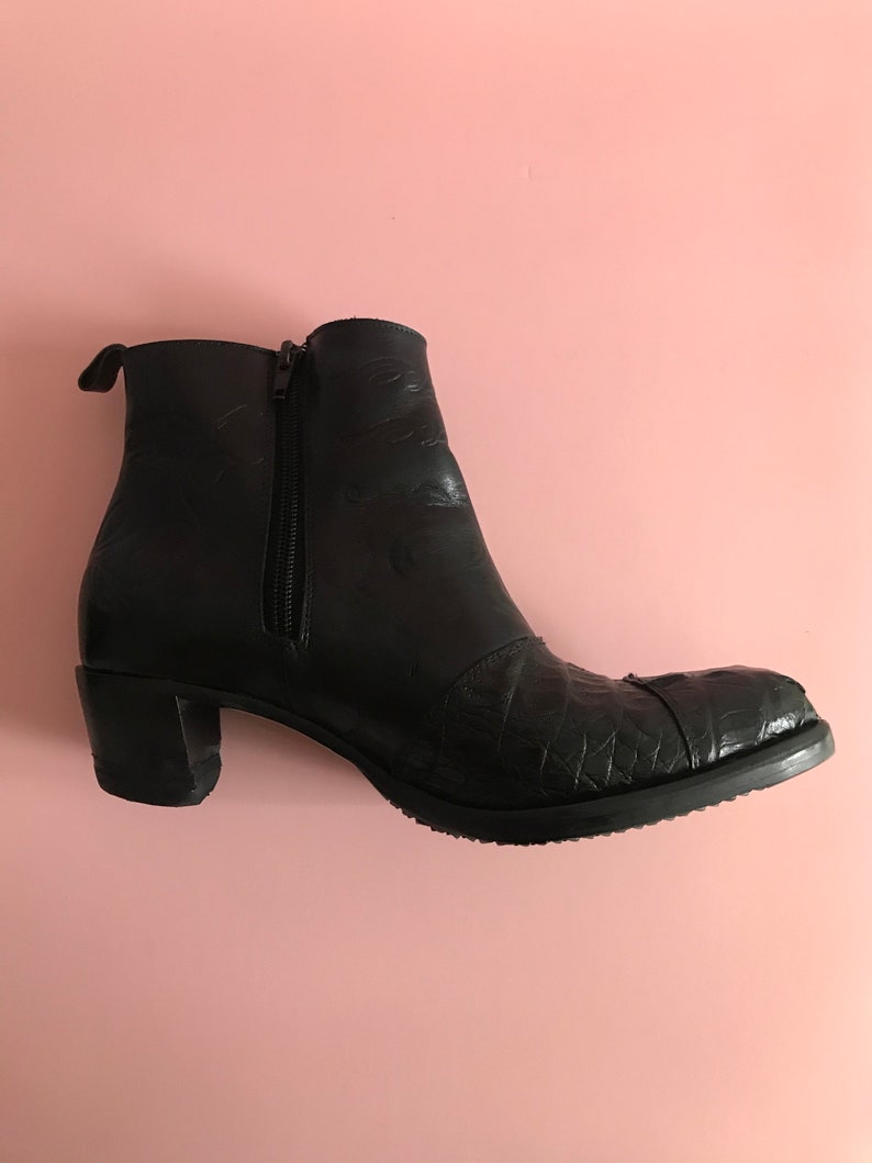 May include: Black leather ankle boots with a zipper on the side and a textured pattern on the toe.