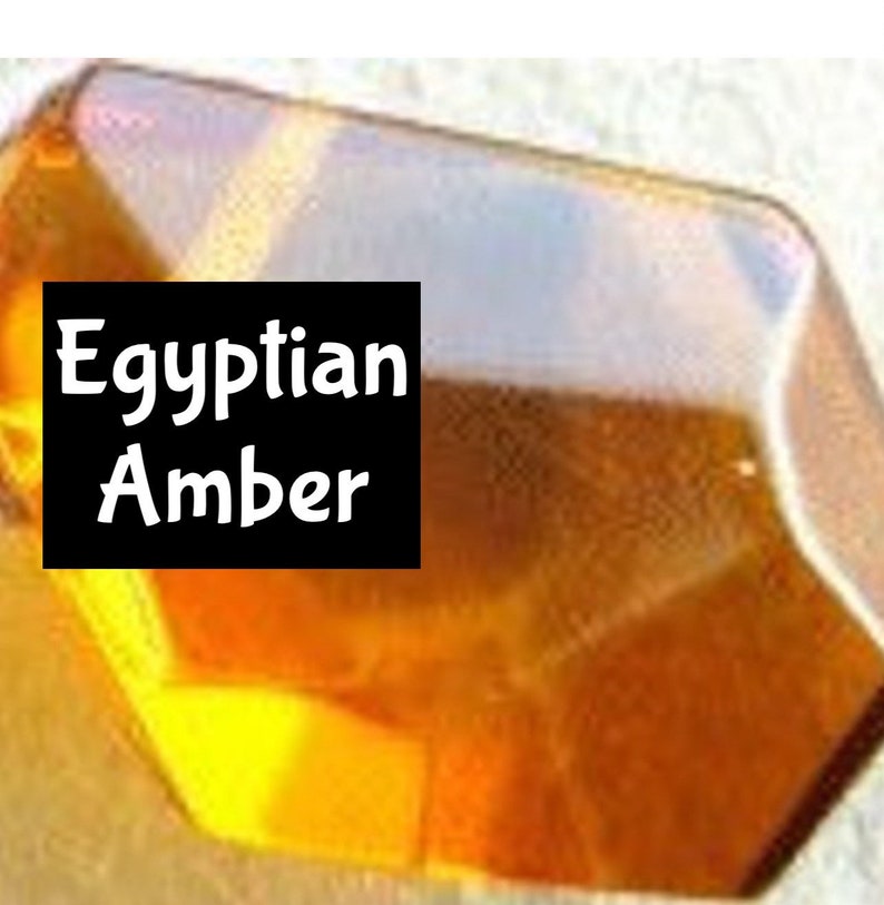 Puede incluir: Primer plano de un trozo de &aacute;mbar, una resina de &aacute;rbol fosilizada, de color amarillo-naranja. El &aacute;mbar est&aacute; etiquetado como "Egyptian Amber".