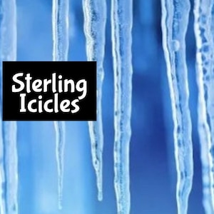 May include: Close-up of several long, clear icicles hanging from a roof. The icicles are all different lengths and have a slight blue tint. The background is a blurry blue sky. The text "Sterling Icicles" is in the lower left corner of the image.