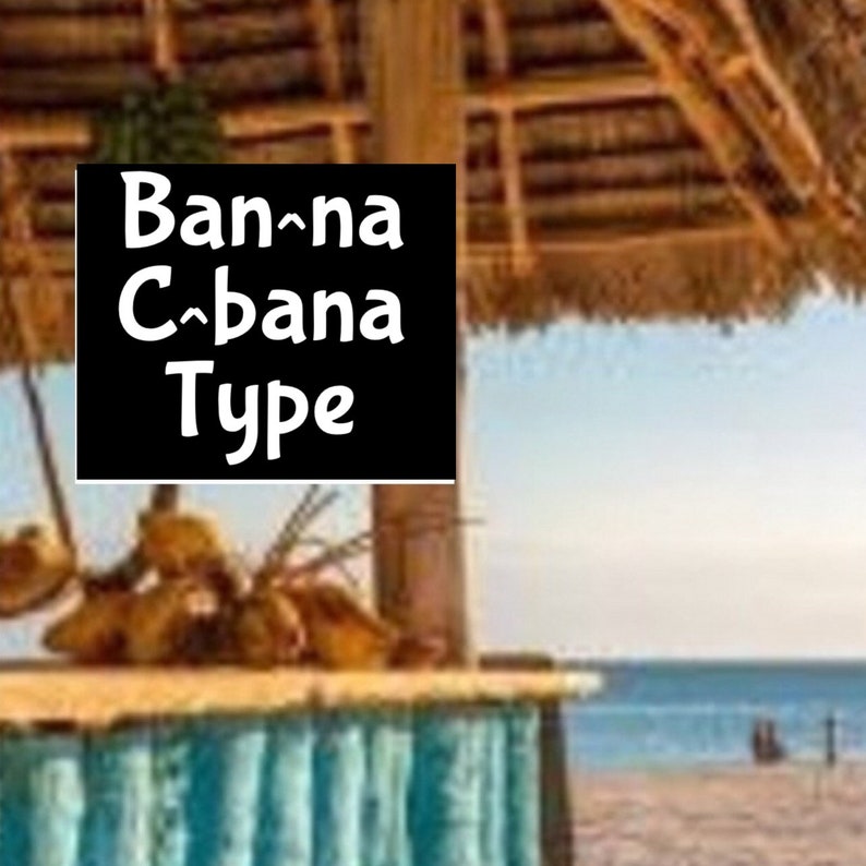 Może przedstawiać: Drewniana chatka plażowa z dachem ze słomy i tabliczką z napisem "Banana Cabana Type". Chatka znajduje się na piaszczystej plaży z niebieską wodą w tle.