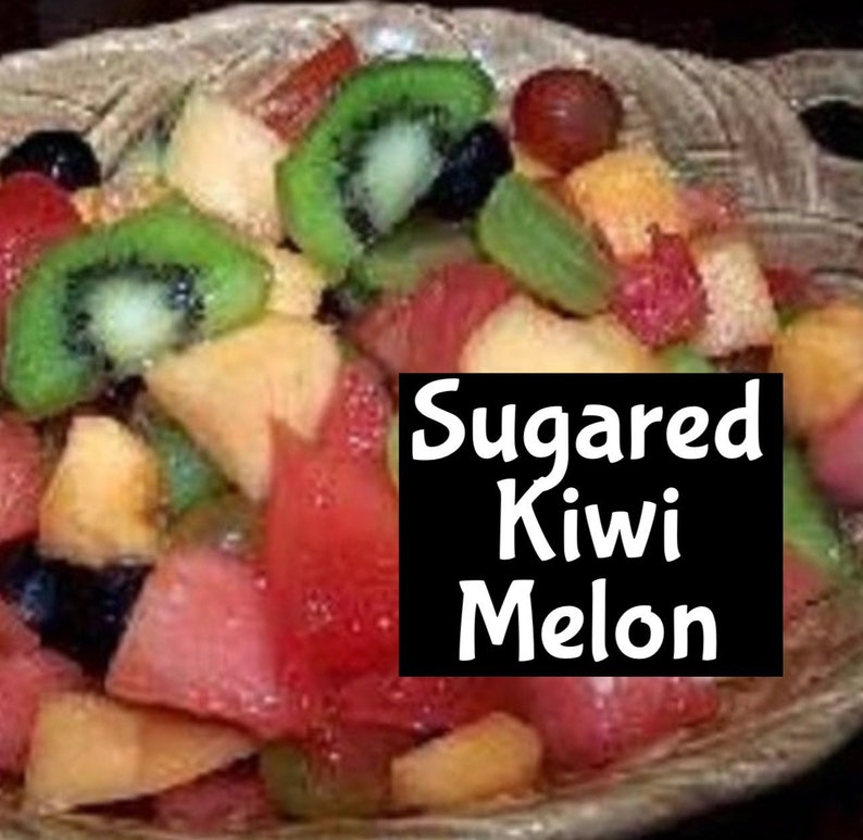 Op de afbeelding: Een kom fruitsalade met kiwi, meloen en rode bessen. De salade is gelabeld "Sugar Kiwi Melon".