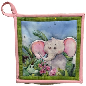 May include: Square quilted potholder with a charming illustration of a baby elephant and a crocodile in a jungle scene. The potholder has a pink border and a green patterned trim. A loop is attached for hanging. The design features pink ears on the elephant.